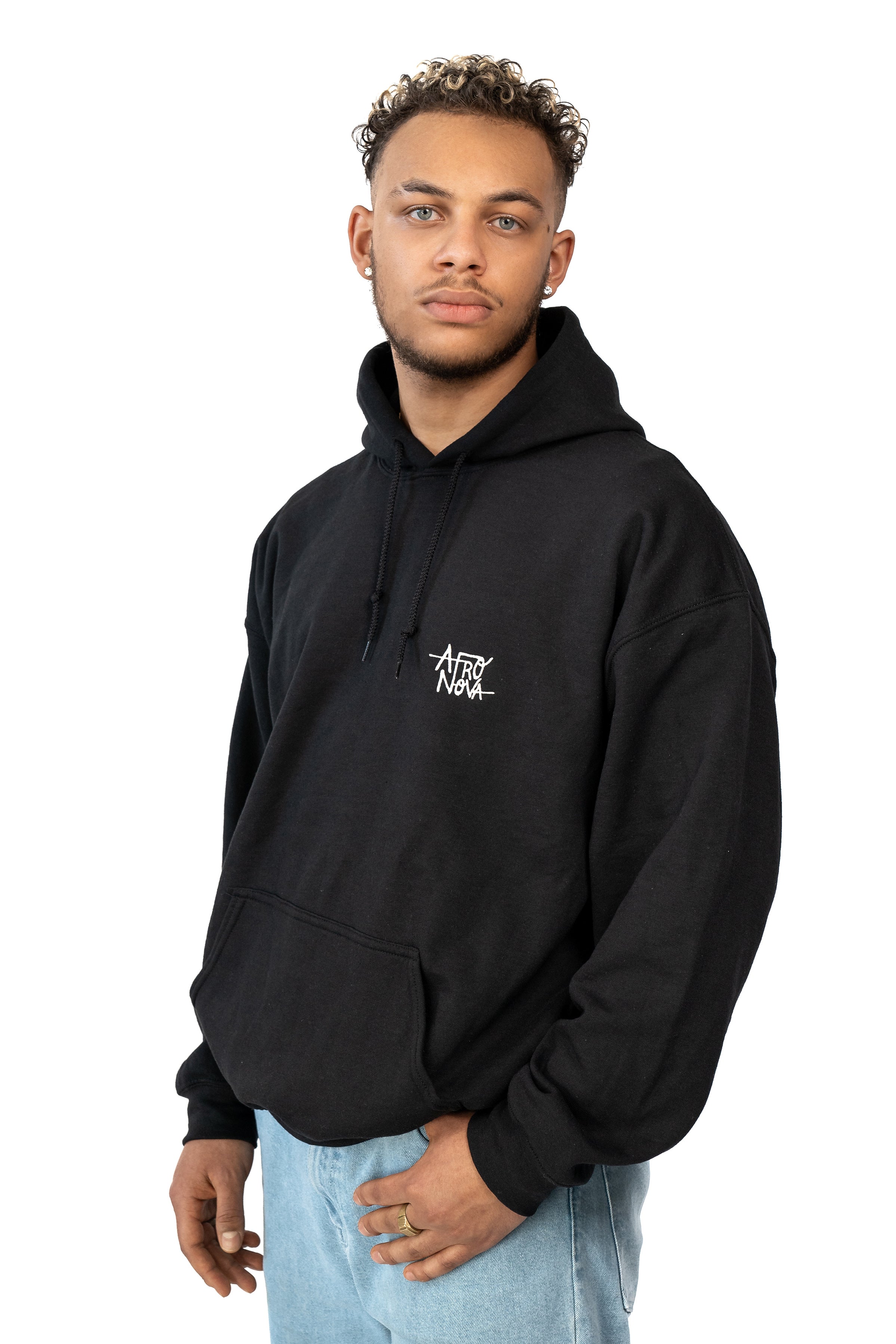 Man with curly hair and earrings wearing a casual black hoodie 